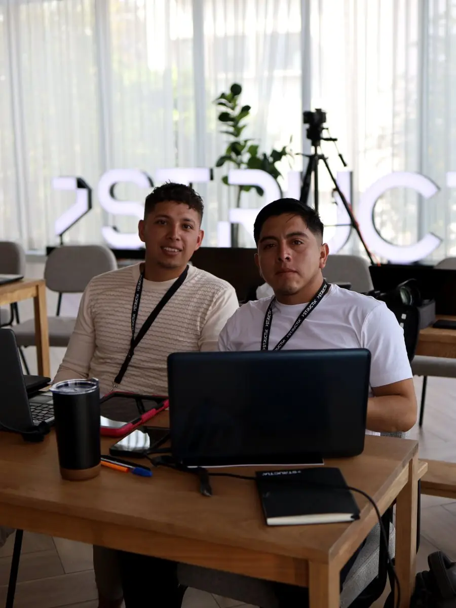 Alumnos trabajando frente al letrero de Structia